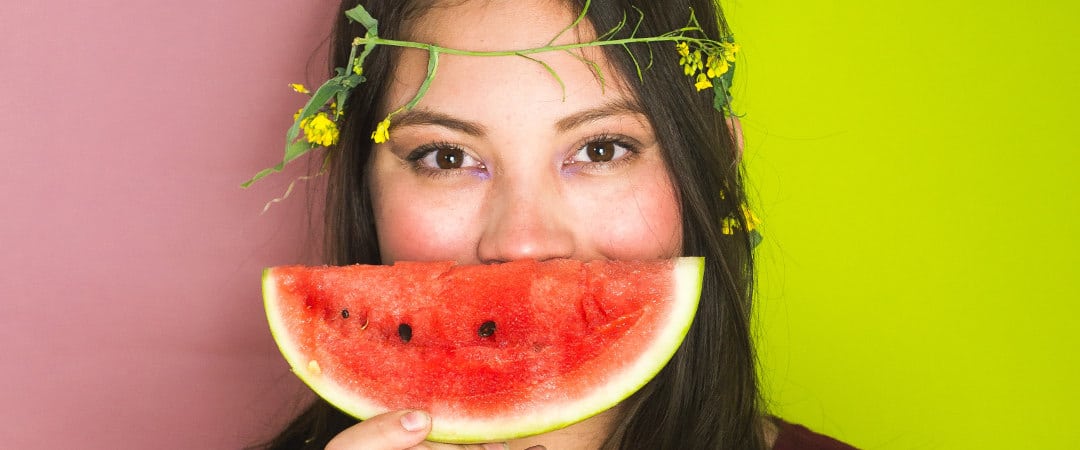 woman holding a slice of watermelon