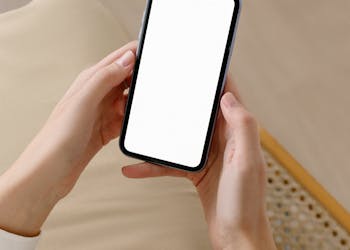 Woman holding smartphone with blank screen for mockup or design purposes, ideal for advertising.
